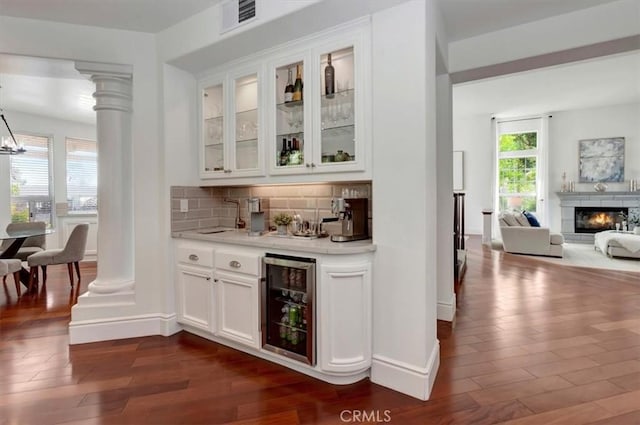 14043 Shepherd Dr, Rancho Cucamonga, CA 91739 - indoor bar with beverage cooler, dark wood-type flooring, decorative columns, and backsplash
