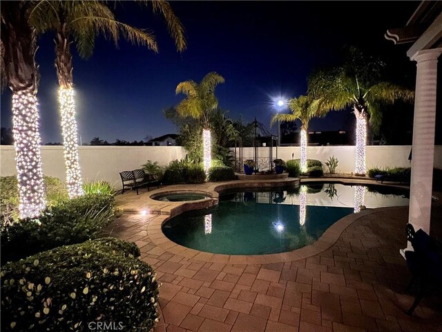 14043 Shepherd Dr, Rancho Cucamonga, CA 91739 - pool at night with a patio area, a fenced backyard, and a pool with connected hot tub