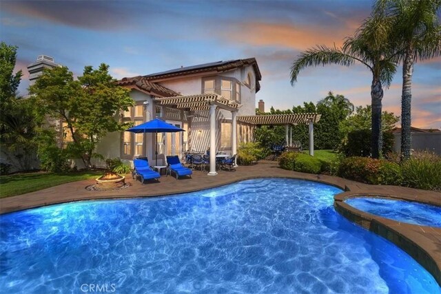 14043 Shepherd Dr, Rancho Cucamonga, CA 91739 - pool at dusk with a pergola, a patio, a pool with connected hot tub, and an outdoor fire pit