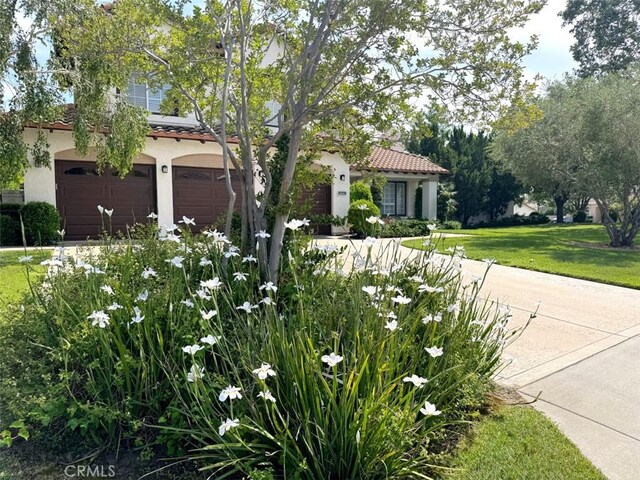 14043 Shepherd Dr, Rancho Cucamonga, CA 91739 - mediterranean / spanish-style house with an attached garage, stucco siding, a tiled roof, and a front yard