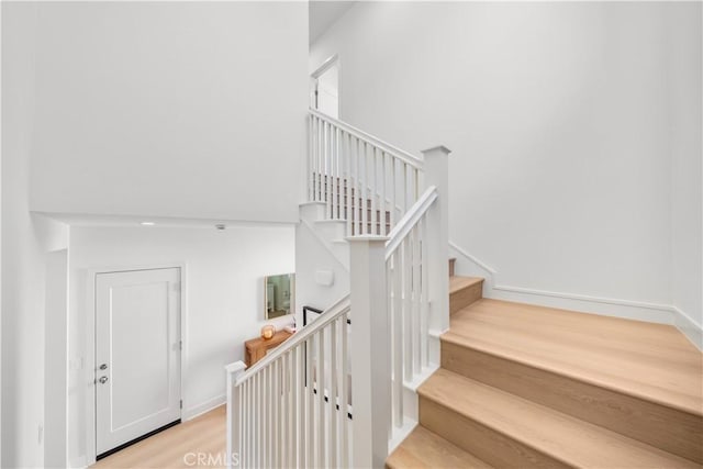 312 Carefree, Irvine, CA 92618 - stairway featuring a towering ceiling, baseboards, and wood finished floors