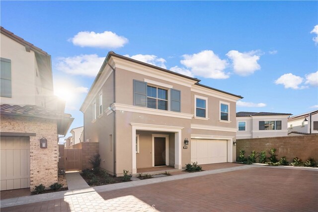 312 Carefree, Irvine, CA 92618 - view of front of house featuring a garage, stucco siding, fence, and decorative driveway