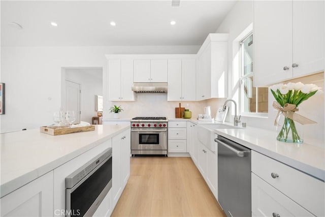 312 Carefree, Irvine, CA 92618 - kitchen featuring light countertops, under cabinet range hood, white cabinetry, recessed lighting, and stainless steel appliances