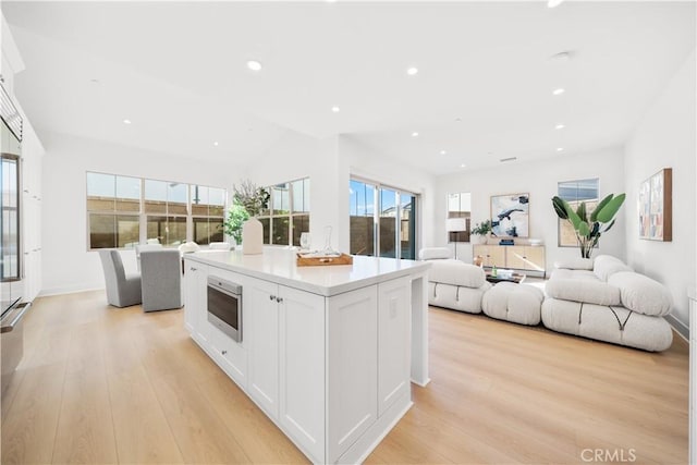 312 Carefree, Irvine, CA 92618 - kitchen featuring white cabinetry, open floor plan, light wood-style floors, and wall oven