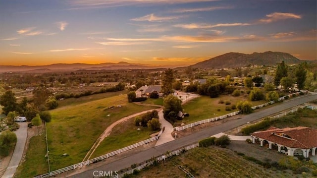 aerial view at dusk featuring a rural view and a mountain view