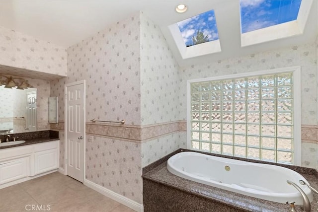 bathroom with a skylight, wallpapered walls, vanity, and a healthy amount of sunlight