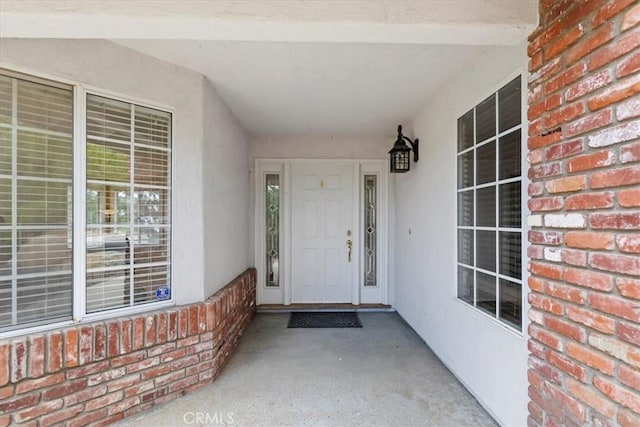doorway to property with brick siding and stucco siding
