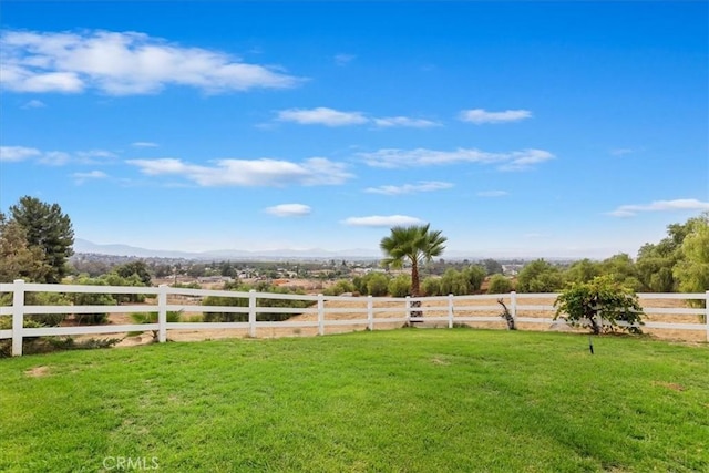 view of yard with a rural view, a mountain view, and fence