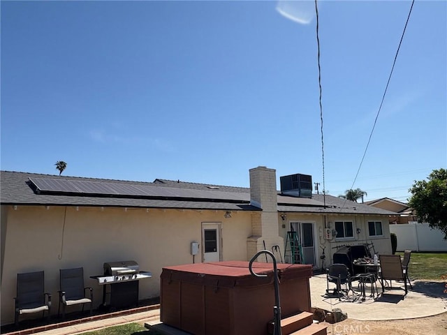 3670 Upper Terrace Dr, Riverside, CA 92505 - rear view of property with a patio, roof mounted solar panels, a hot tub, fence, and stucco siding