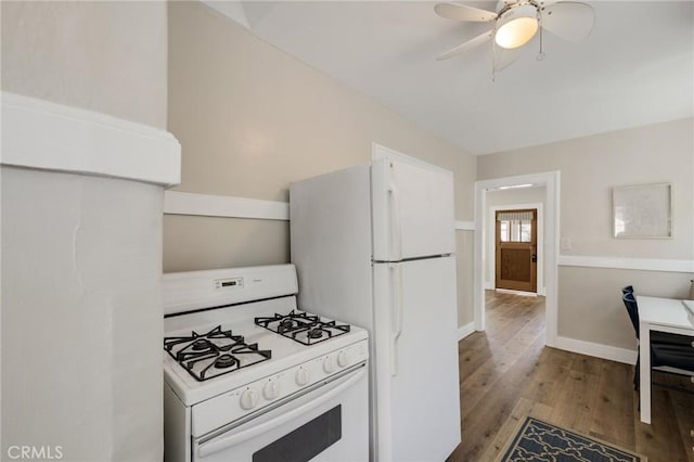 kitchen featuring light wood-style flooring, a ceiling fan, white appliances, and baseboards