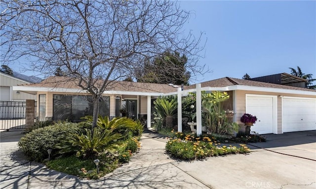 ranch-style home with a garage and fence