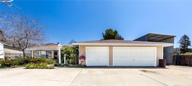 ranch-style house with fence and a detached garage
