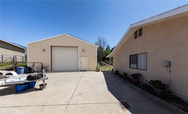 detached garage with fence and driveway
