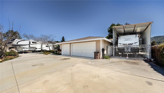 view of side of property with fence and a detached garage