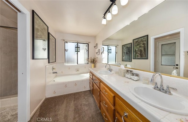 full bath featuring double vanity, a bath, baseboards, and a sink