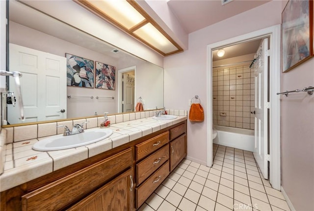 full bathroom featuring tile patterned floors, double vanity, a sink, and baseboards