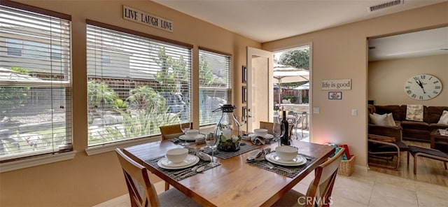 dining area featuring light tile patterned floors, baseboards, and visible vents