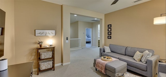 carpeted living area with visible vents, ceiling fan, and baseboards
