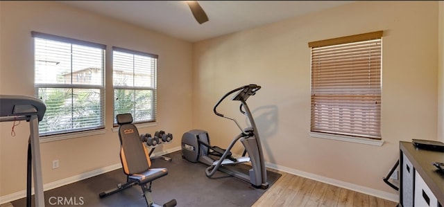 workout area with baseboards, a ceiling fan, and a healthy amount of sunlight
