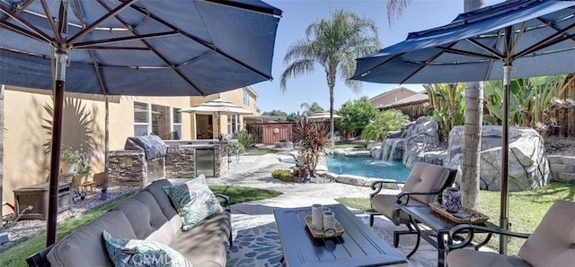 view of patio / terrace featuring exterior kitchen, outdoor lounge area, a grill, and fence