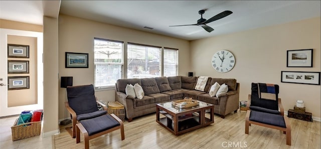 living area featuring light wood finished floors, visible vents, baseboards, and a ceiling fan