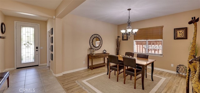 dining room featuring light wood finished floors, a notable chandelier, and a healthy amount of sunlight