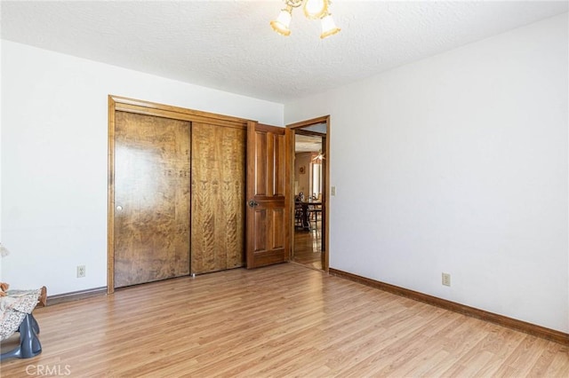 7040 Kenyon Ave, Hesperia, CA 92345 - unfurnished bedroom featuring light wood-type flooring, baseboards, and a textured ceiling