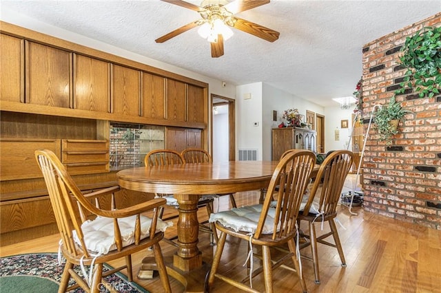 7040 Kenyon Ave, Hesperia, CA 92345 - dining room featuring light wood-style flooring, a textured ceiling, ceiling fan, and visible vents