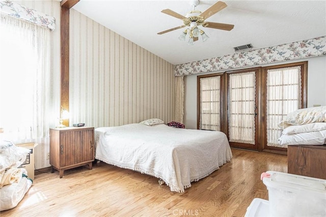 7040 Kenyon Ave, Hesperia, CA 92345 - bedroom with visible vents, a ceiling fan, wood finished floors, wallpapered walls, and lofted ceiling