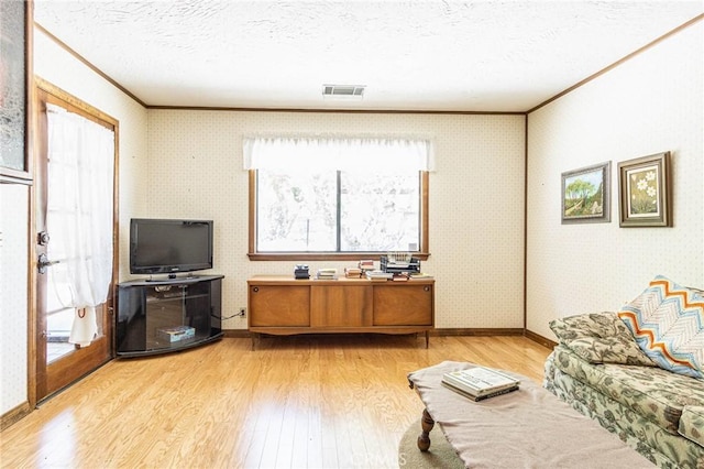 7040 Kenyon Ave, Hesperia, CA 92345 - living area with baseboards, light wood-type flooring, ornamental molding, a textured ceiling, and visible vents