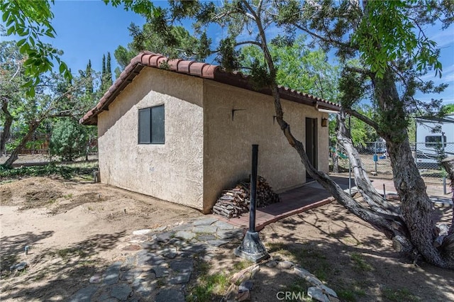 7040 Kenyon Ave, Hesperia, CA 92345 - view of home's exterior featuring stucco siding, fence, and a tile roof