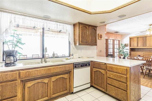 7040 Kenyon Ave, Hesperia, CA 92345 - kitchen with a peninsula, light countertops, brown cabinets, dishwasher, and a sink