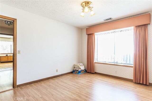 7040 Kenyon Ave, Hesperia, CA 92345 - empty room featuring a wealth of natural light, visible vents, and light wood-type flooring