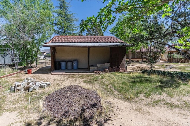 7040 Kenyon Ave, Hesperia, CA 92345 - back of property featuring an outdoor structure, stucco siding, a tiled roof, and fence