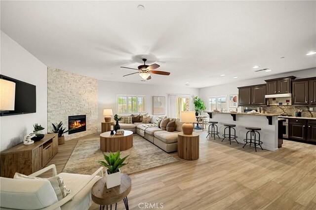 73992 Van Gogh Dr, Palm Desert, CA 92211 - living room with a stone fireplace, light wood-style flooring, a ceiling fan, and recessed lighting