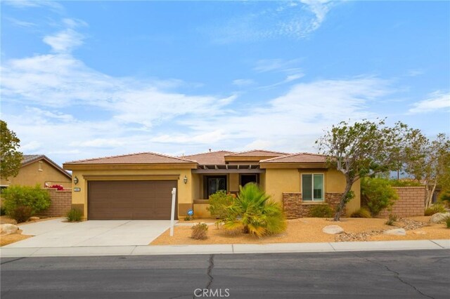 73992 Van Gogh Dr, Palm Desert, CA 92211 - prairie-style home with an attached garage, concrete driveway, stucco siding, fence, and stone siding
