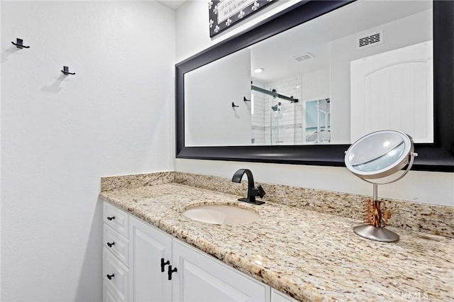 bathroom with vanity, visible vents, and a stall shower