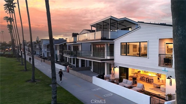 exterior space with a front lawn, a patio, and a balcony