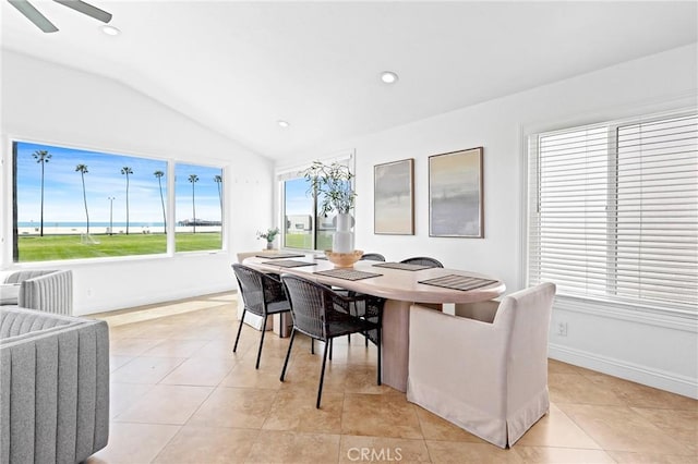 dining room with light tile patterned floors, baseboards, a ceiling fan, and vaulted ceiling