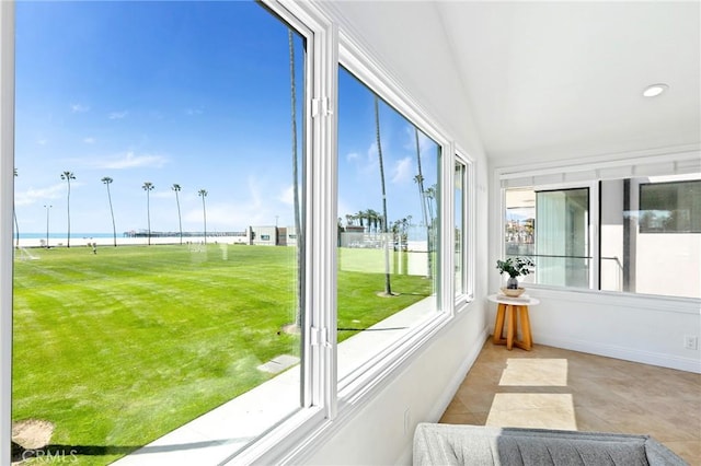 sunroom / solarium featuring recessed lighting, baseboards, tile patterned flooring, and a water view