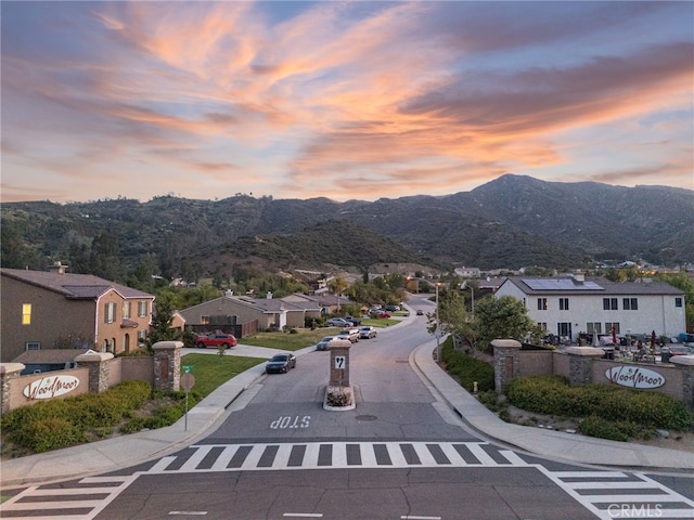 view of street featuring sidewalks, a residential view, a mountain view, and curbs