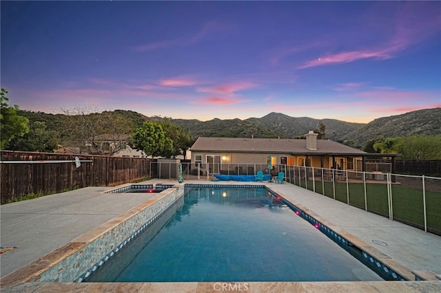 view of pool with fence, a patio, a fenced in pool, an in ground hot tub, and a mountain view
