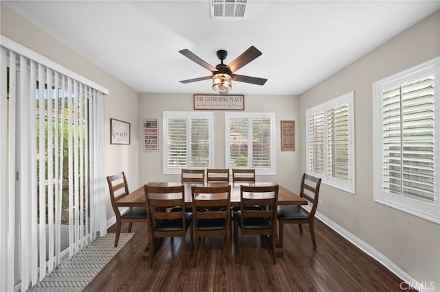 dining area with dark wood-type flooring, a ceiling fan, baseboards, and visible vents