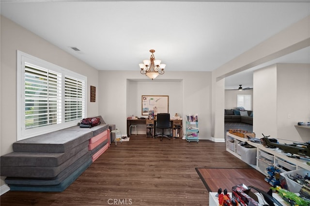 living area featuring baseboards, ceiling fan with notable chandelier, wood finished floors, and visible vents