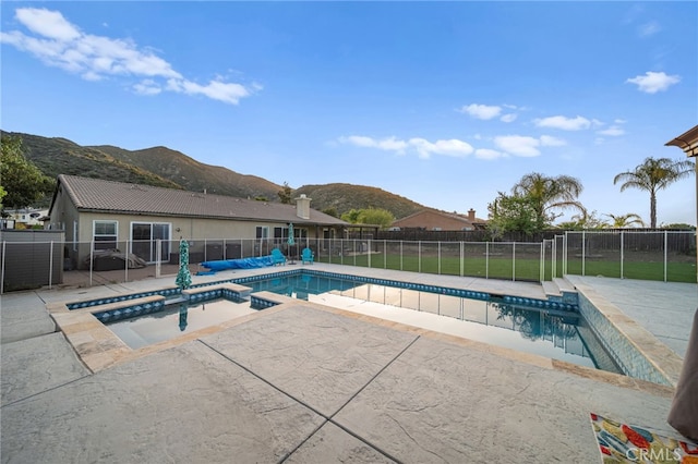 view of swimming pool with a patio, fence, and a mountain view