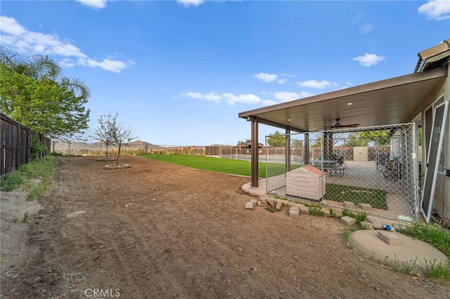 view of yard featuring a fenced backyard and ceiling fan