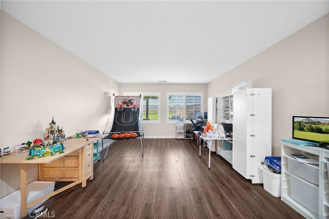 recreation room featuring baseboards and dark wood-style floors