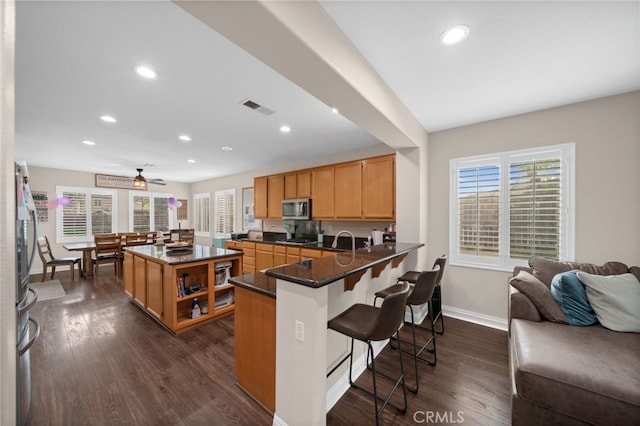 20536 Black Walnut Ct, Wildomar, CA 92595 - kitchen featuring stainless steel microwave, dark wood finished floors, baseboards, recessed lighting, and a breakfast bar