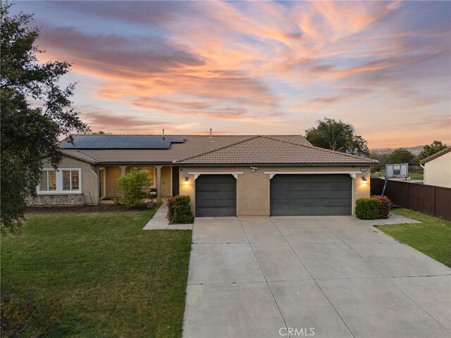 single story home with fence, stucco siding, concrete driveway, an attached garage, and a tile roof