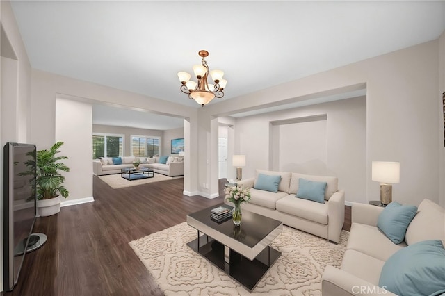 living room with an inviting chandelier, baseboards, and dark wood-style floors